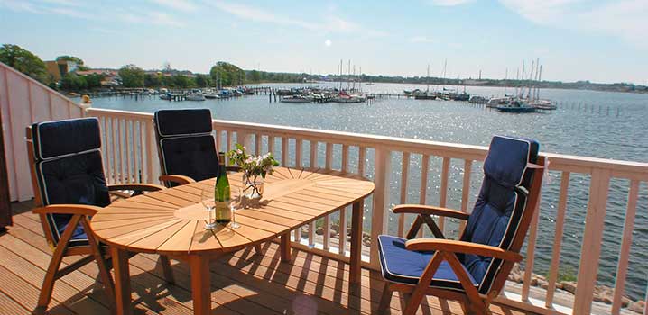 Vom Balkon Ihrer Ferienwohnung können Sie eine schöne Aussicht über den Yachthafen genießen Drei Stühle um einen Tisch auf einem Balkon mit Aussicht über den Yachthafen