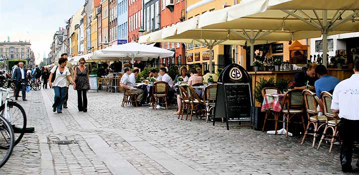 Im Sommer ist es schön, draußen das Essen oder ein kaltes Getränk zu genießen Menschen auf der Außenterrasse bei einem Yachthafen