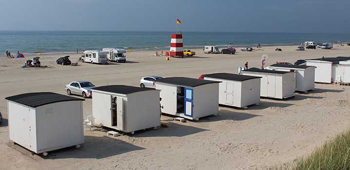 Die charakteristischen weißen Badehäuser und Rettungsschwimmerturm am Strand von Løkken Die charakteristischen weißen Badehäuser und Rettungsschwimmerturm am Strand von Løkken