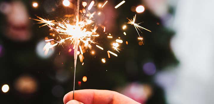 Gemütlichkeit im Ferienhaus zu Silvester mit Wunderkerzen Eine Frau hält eine Wunderkerze
