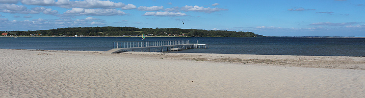 Bred sandstrand med badebro i bugten ved sommerhusområdet Diernæs Bred sandstrand med badebro i bugten ved sommerhusområdet Diernæs