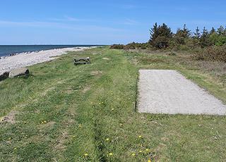 Petanquebana och bänkar bortom stranden i sommarstugeområdet Helligsø Petanquebana och bänkar bortom stranden i sommarstugeområdet Helligsø