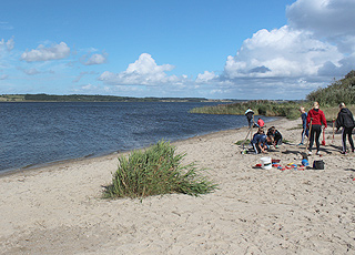 Barn gräver i sanden på den lilla sandstranden i Hjarbæk Barn gräver i sanden på den lilla sandstranden i Hjarbæk