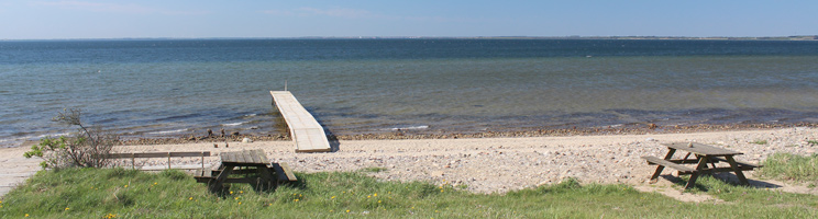 Badesteg und Bänke an dem Badestrand und dem klaren Badewasser in Hostrup Badesteg und Bänke an dem Badestrand und dem klaren Badewasser in Hostrup