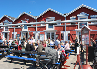 De røde pakhuse på havnen i Skagen Midtby, hvor I kan nyde fisk i alle afskygninger De røde pakhuse på havnen i Skagen Midtby, hvor I kan nyde fisk i alle afskygninger