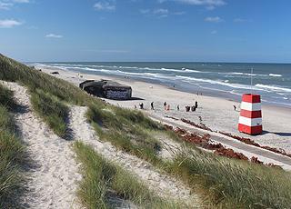 Livreddertårn, bunkere og badegæster på Søndervigs brede sandstrand Livreddertårn, bunkere og badegæster på Søndervigs brede sandstrand