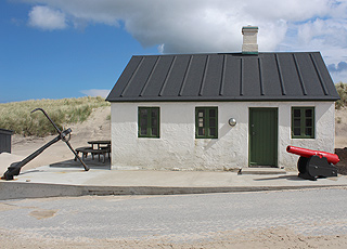 Eines der kleinen Fischerhäuser in Stenbjerg mit Anker und Kanone Eines der kleinen Fischerhäuser in Stenbjerg mit Anker und Kanone