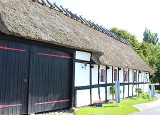 Historisk bindingsværkshus med stråtag bag sommerhusene i Tårup Historisk bindingsværkshus med stråtag bag sommerhusene i Tårup