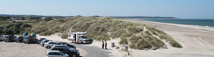 Bred sandstrand i Tranum og sommerhuse i klitterne bag stranden Bred sandstrand i Tranum og sommerhuse i klitterne bag stranden