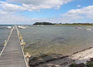 Long landing stage by the beach in Varnæs and a view of the point Varnæs Hoved Long landing stage by the beach in Varnæs and a view of the point Varnæs Hoved