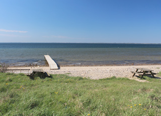 Ein schöner Limfjord-Badestrand mit einem Badesteg in Hostrup Ein schöner Limfjord-Badestrand mit einem Badesteg in Hostrup