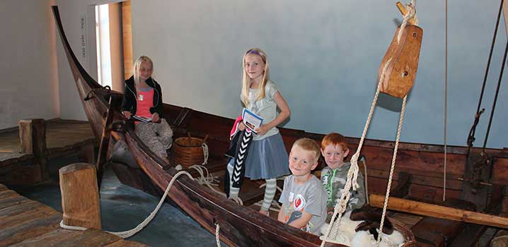 Spielende Kinder im Wikingerschiff des Museums / Museet Ribes Vikinger Spielende Kinder im Wikingerschiff des Museums / Museet Ribes Vikinger
