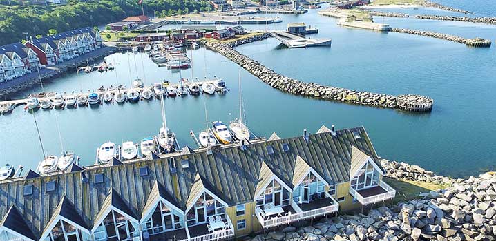 Einladender kleiner Bootsanleger mit Ferienhäusern direkt am Wasser. ferienhaus-am-strand-mit-anleger-und-booten