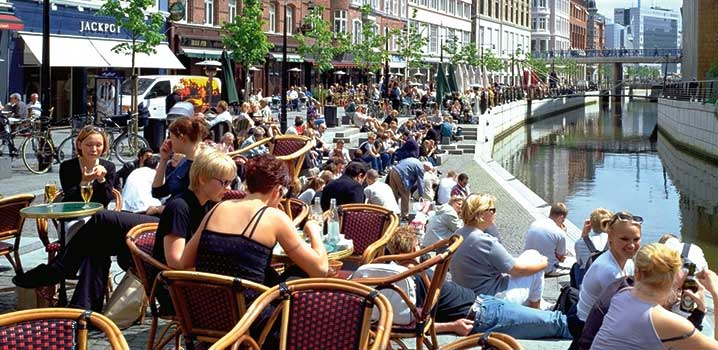 Gäste genießen den Besuch in einem Café direkt am Kanal schoenste-orte-daenemarks-menschen-sitzen-in-cafe-am-kanal