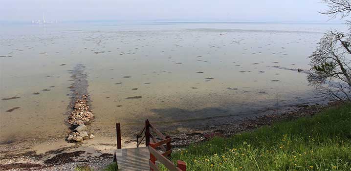 Strand mit Treppe Treppe zum Strand mit Steinen
