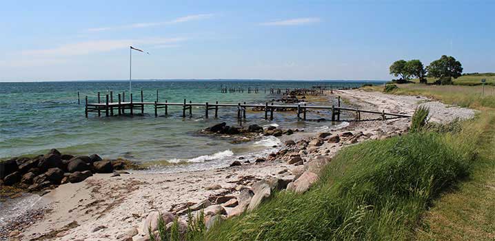 Steinstrand auf Helnäs Strand mit Badebrücke