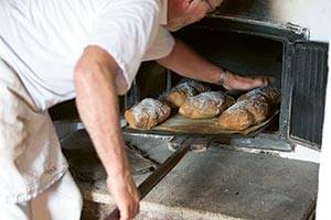 Sehen Sie, wie das alte Handwerk in der Mühle Bundsbæk Mølle ausgeführt wird Brot wird aus dem Ofen genommen