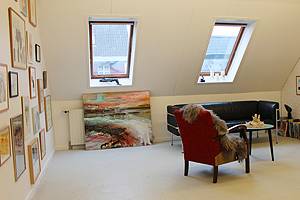 Billedkunst på væggene i det hyggelige loftsrum Hyggeligt loftsrum med billedkunst og kunsthåndværk