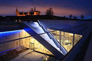 Museumsbygningen med Kronborg i baggrunden Museet oplyst i mørke