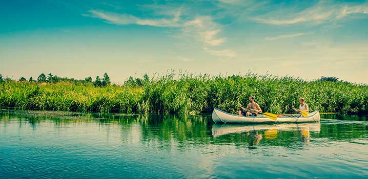To personer i en kano på en å