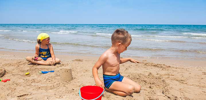 Zwei Kinder graben am Strand im Sand