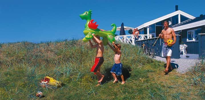 Familie mit Strandspielzeug an der Ferienhaus