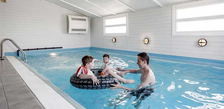 Kinder spielen im Swimmingpool im Ferienhaus