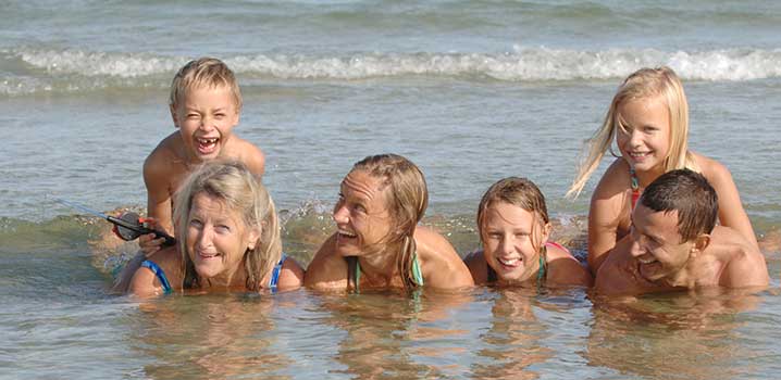 Familie i vandkanten på stranden