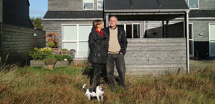 Paar mit Hund im Urlaub in einem Ferienhaus